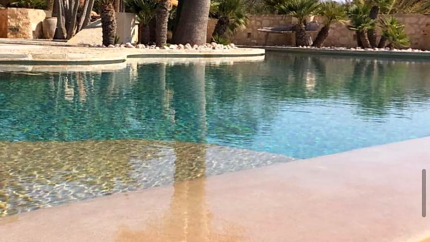 Detalle de la playa de entrada de una piscina de arena de cuarzo